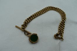 A yellow metal curb link watch chain with T bar and 9ct gold fob having glass panels,