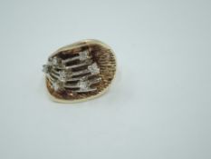 A yellow metal dress ring having seven small diamonds, total approx 0.25ct in a stylised botanical