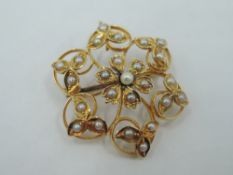 An Edwardian yellow metal brooch/pendant stamped 15ct having seed pearl floral decoration, approx