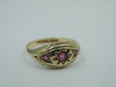 A 9ct gold band ring having a trio of inset graduated rubies in a shaped panel, size N & 1.6g
