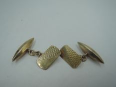 A pair of 9ct gold cufflinks having engine turned rectangular plaques with chain connectors to