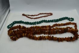 A long string of rough cut Baltic amber, string of branch coral and knotted string of green '