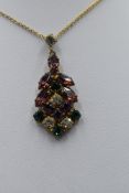 A vintage costume jewellery pendant and chain in Suffragette colours having paste purple, green