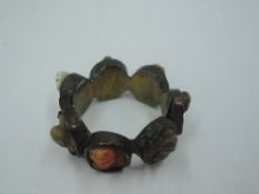 A base metal band ring comprising of seven plaques of various classical busts, size Q
