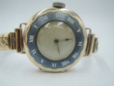 A vintage 9ct gold wrist watch having a plain face and Roman numeral dial bezel to the front case