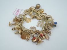 A yellow metal fancy link charm bracelet stamped 10K having approx 50 yellow metal charms, several