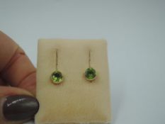 A pair of peridot style solitaire stud earrings in yellow metal collared mounts, approx 2g