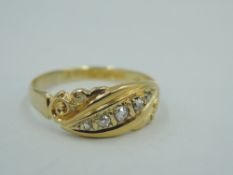 An Edwardian 18ct gold band ring having five small graduated diamonds in a moulded panel, size Q &