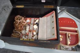 A vintage leather travel box containing a selection of vintage costume jewellery including clip