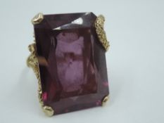 An oversized amethyst dress ring having a large rectangular stone in a stylised and decorative