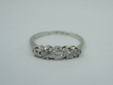 A five stone graduated diamond dress ring , total approx 0.35ct in a raised claw mount on a white