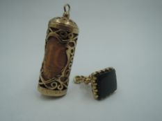A 9ct gold canister charm having open decoration and containing a 10 Shilling note, and a 9ct gold