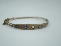 A Victorian 9ct rose gold hinged bangle having sapphire and diamond set lozenge shaped panel and