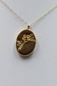A 9ct gold small oval locket having floral 3D decoration, approx 18' & 2.5g