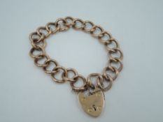 A rose gold curb link bracelet stamped 9ct having a 9ct rose gold padlock clasp, approx 18g