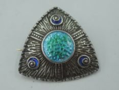 A silver and enamel brooch of triangular form having blue, green and turquoise decoration to