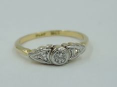 A three stone diamond dress ring having a central collared diamond flanked by two diamonds in
