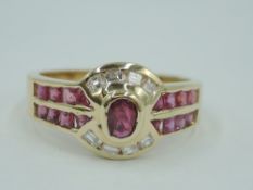 A diamond and ruby dress ring having a central oval ruby, approx 0.05ct flanked by eight baguette