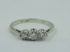 A diamond trilogy dress ring, total approx 0.20ct in a claw set mount on a white metal loop