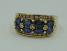 A 14ct gold band ring having a double row of marquise cut powder blue sapphires bordered and