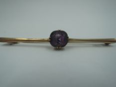 A yellow metal bar brooch stamped 9ct having central facetted amethyst, approx 3.9g