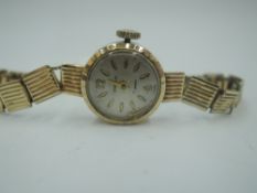 A 9ct gold wrist watch by Sekonda having a baton numeral dial to small face in gold case on rolled