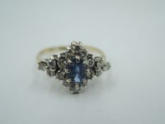 A powder blue sapphire and diamond lozenge shaped cluster in a claw set basket mount on a 9ct gold