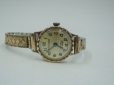 A 9ct gold wrist watch by Excalibur having Arabic numeral dial to champagne face on a gold plated