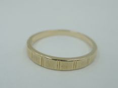 A yellow metal band ring stamped 14K having ridged decoration, size P & approx 2.6g