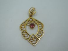 A 9ct gold open pendant having a central ruby within a filigree style mount, approx 2.2g (no chain)