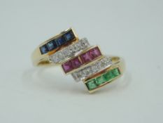 A multi stone dress ring having rows of baguette cut emeralds, rubies & sapphires interspersed by