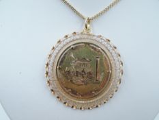 A yellow metal oversized pendant of circular form stamped 750 bearing engraved Greek scenic panels