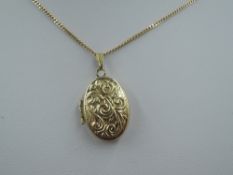 A small oval yellow metal locket stamped 9ct having moulded decoration on a fine 9ct gold curb