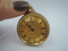 A small yellow metal top wound pocket watch having Roman numeral dial on engraved face in
