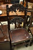A period oak hall chair having interesting carved decoration mythical possibly fertility related?