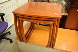 A vintage teak nest of three stylised tables