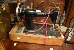 A vintage hand crank Singer sewing machine and a brass companion set