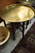 A traditional Anglo Indian brass tray top table having turned wood folding base