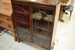 An early 20th Century mahogany bookcase having astral glazed front on short cabriole legs, width