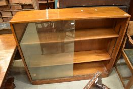 A vintage golden oak bookcase having sliding glass doors, width approx. 114cm