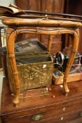 A bamboo effect occasional table with canework and glass top, brass magazine racks and shooting