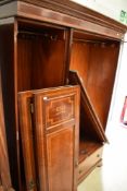 An Edwardian mahogany and inlaid mirror door triple wardrobe