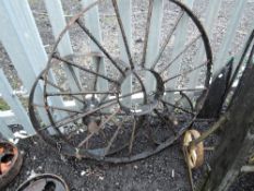 Three cast iron cart or truck wheels of various sizes