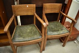 A pair of early 20th Century golden oak carver chairs, in the Arts and Crafts style, similar to