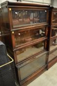 An early 20th Century oak stacking bookcase unit with drawer base and four glazed tiers, in the