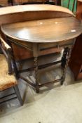 An early 20th Century oak demi lune hall table on twist frame