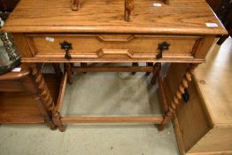 An early 20th Century golden oak side table , having cushioned frieze drawer and twist legs