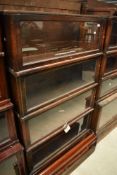 An early 20th Century oak stacking bookcase unit with mismatched mahogany base, having four glazed
