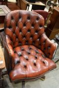 A reproduction office arm chair of leather button back design