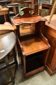 A Victorian mahogany pot cupboard having mirror back and open front, paper label to back for J
